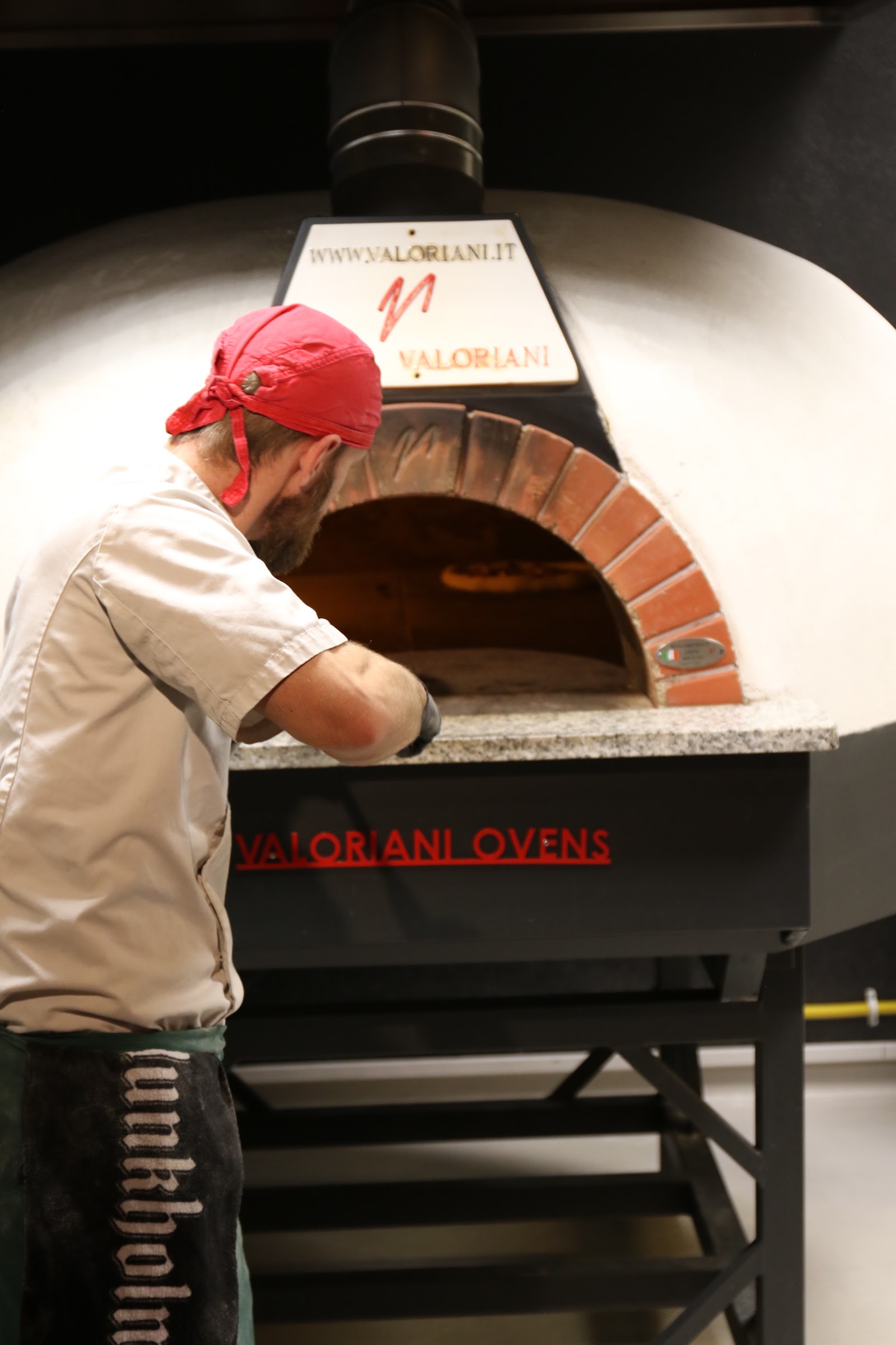 Pizzabaker foran steinovnen hos Kraft Pizzeria
