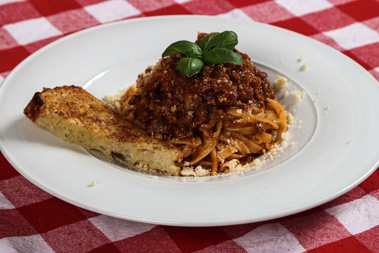Pasta ragu med brød servert på rutete duk
